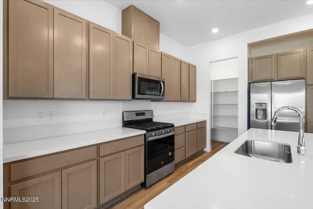 a kitchen with stainless steel appliances a sink a stove cabinets and a kitchen island