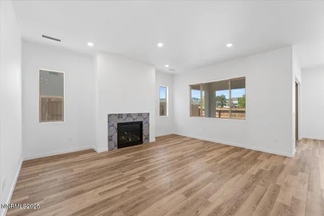 an empty room with windows and fireplace