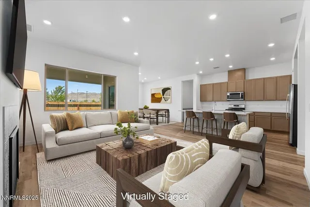 a living room with furniture kitchen and a large window