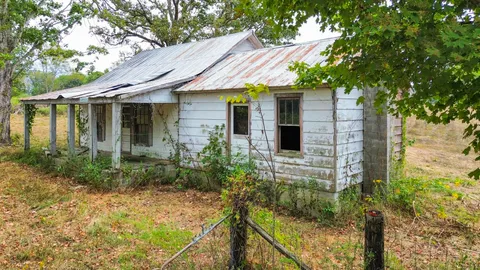 a view of brick house with large windows and plants