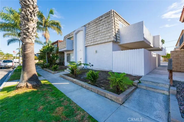 a view of a house with a yard and potted plants