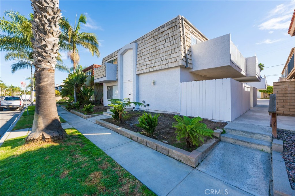 a view of a house with a yard and potted plants