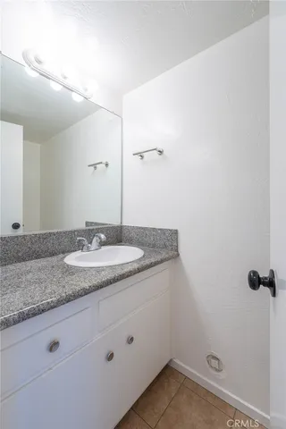 a bathroom with a granite countertop sink and mirror