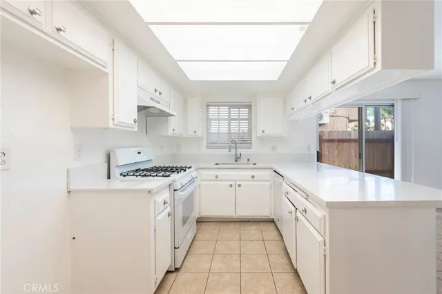 a kitchen with granite countertop a sink stove and cabinets