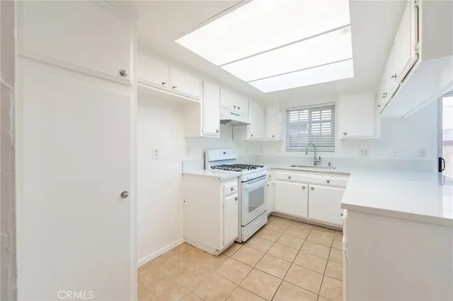 a kitchen with white cabinets and white appliances