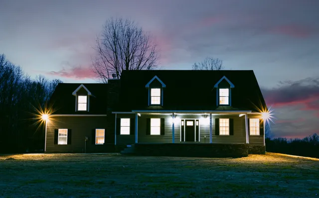 a kitchen with stainless steel appliances granite countertop a refrigerator a sink dishwasher a stove and white cabinets with wooden floor