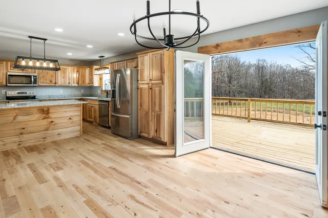 a kitchen with granite countertop stainless steel appliances a sink stove and refrigerator