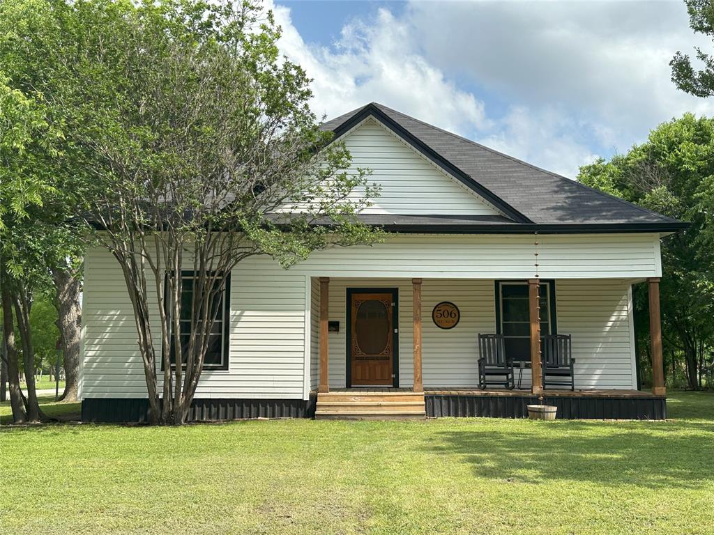 506 Northeast 3rd Street Hubbard, TX 76648 - Photo 1 of 17 a view of a white house with a big yard and potted plants