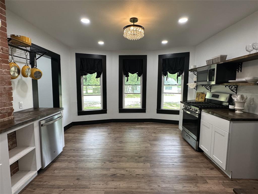 506 Northeast 3rd Street Hubbard, TX 76648 - Photo 6 of 17 a kitchen with stainless steel appliances granite countertop a stove and a wooden floors