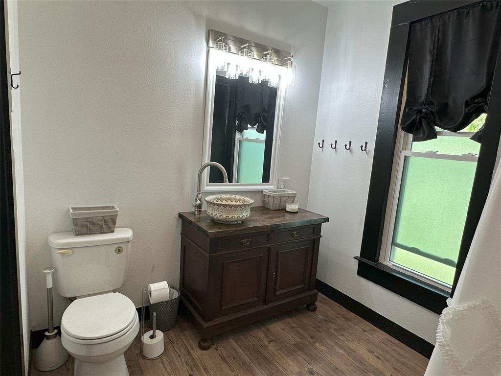 506 Northeast 3rd Street Hubbard, TX 76648 - Photo 9 of 17 a bathroom with a toilet a sink and mirror