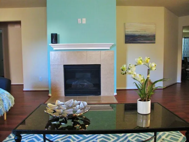 a vase with flowers sitting on a table with wooden floor