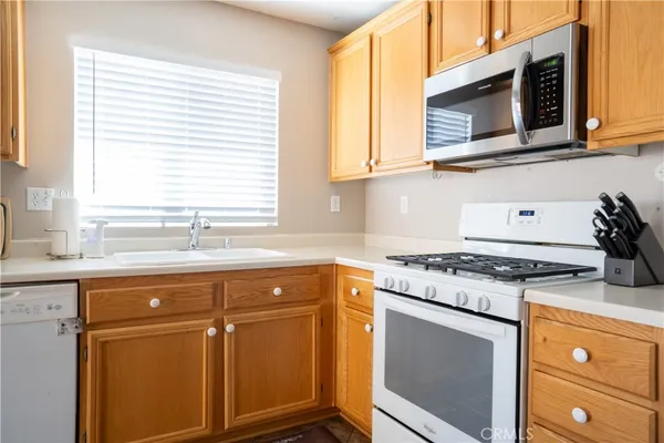 a kitchen with granite countertop cabinets stainless steel appliances and a sink