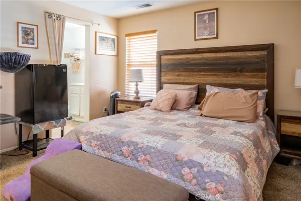 a bedroom with a bed tv and window