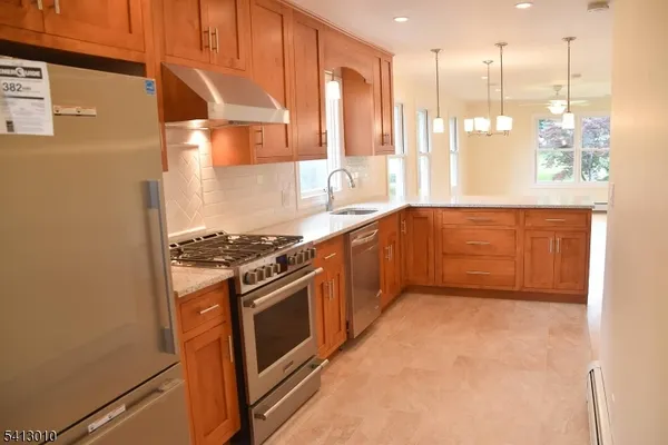 a kitchen with stainless steel appliances granite countertop a stove a sink and a refrigerator
