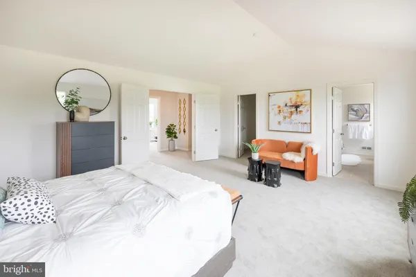 a spacious bedroom with a bed and a chandelier