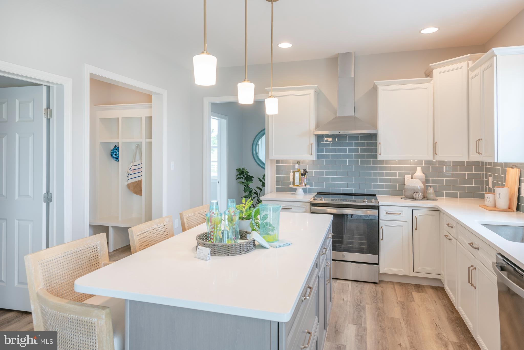 4 Old Orch Road Strasburg, PA 17579 - Photo 3 of 25 a kitchen with stainless steel appliances granite countertop a sink a stove a oven a dining table with chairs and white cabinets