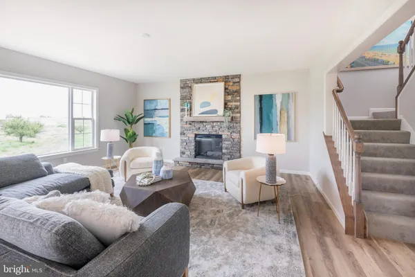 a living room with furniture fireplace and a large window