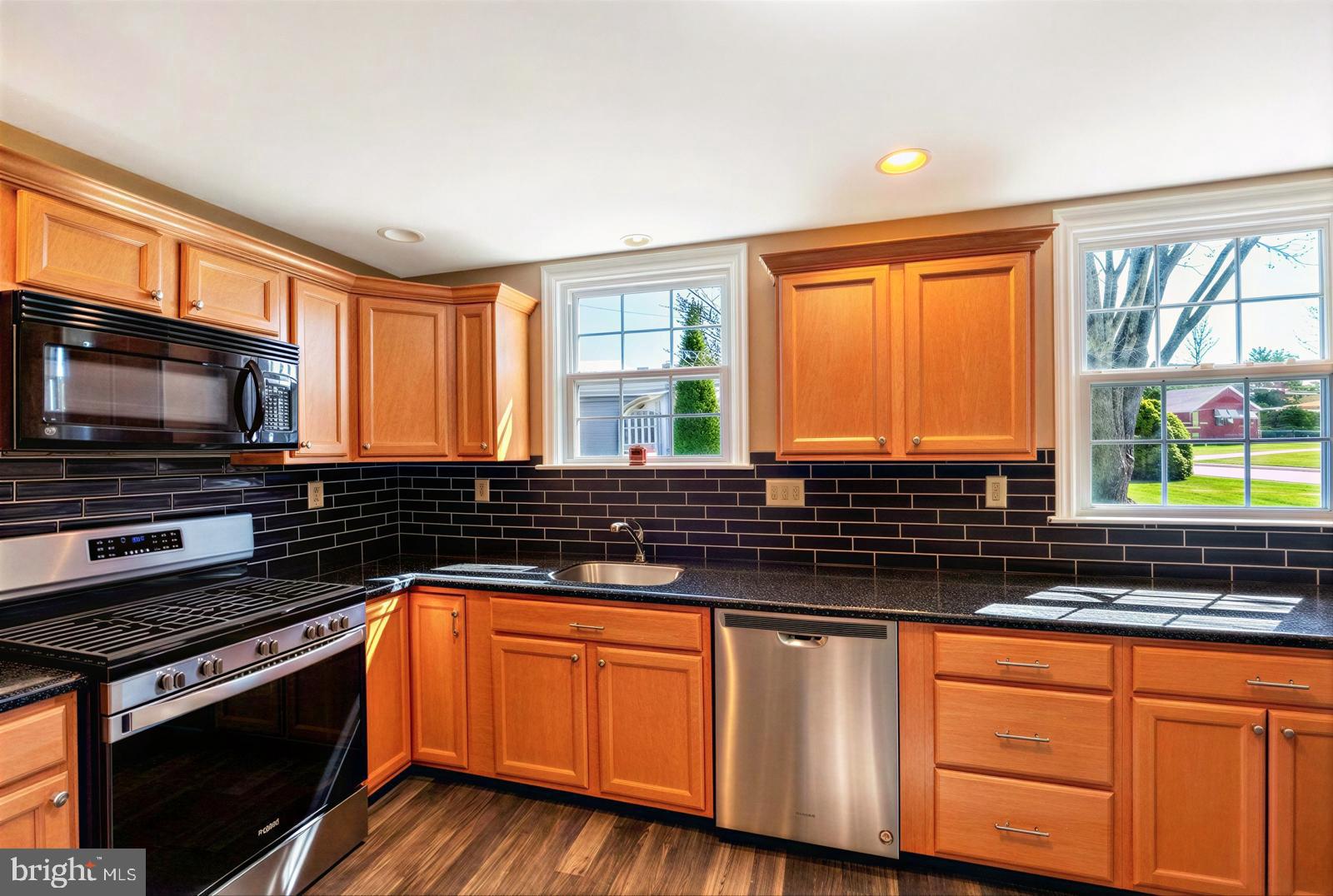 107 Valley View Road Norristown, PA 19401 - Photo 13 of 35 a kitchen with granite countertop wooden cabinets stainless steel appliances and a window