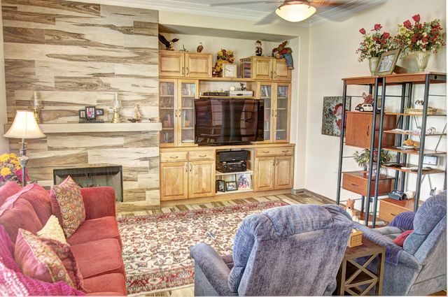 a living room with furniture a flat screen tv and a fireplace
