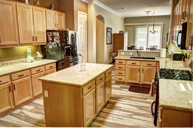 a kitchen with a stove a sink a refrigerator and cabinets
