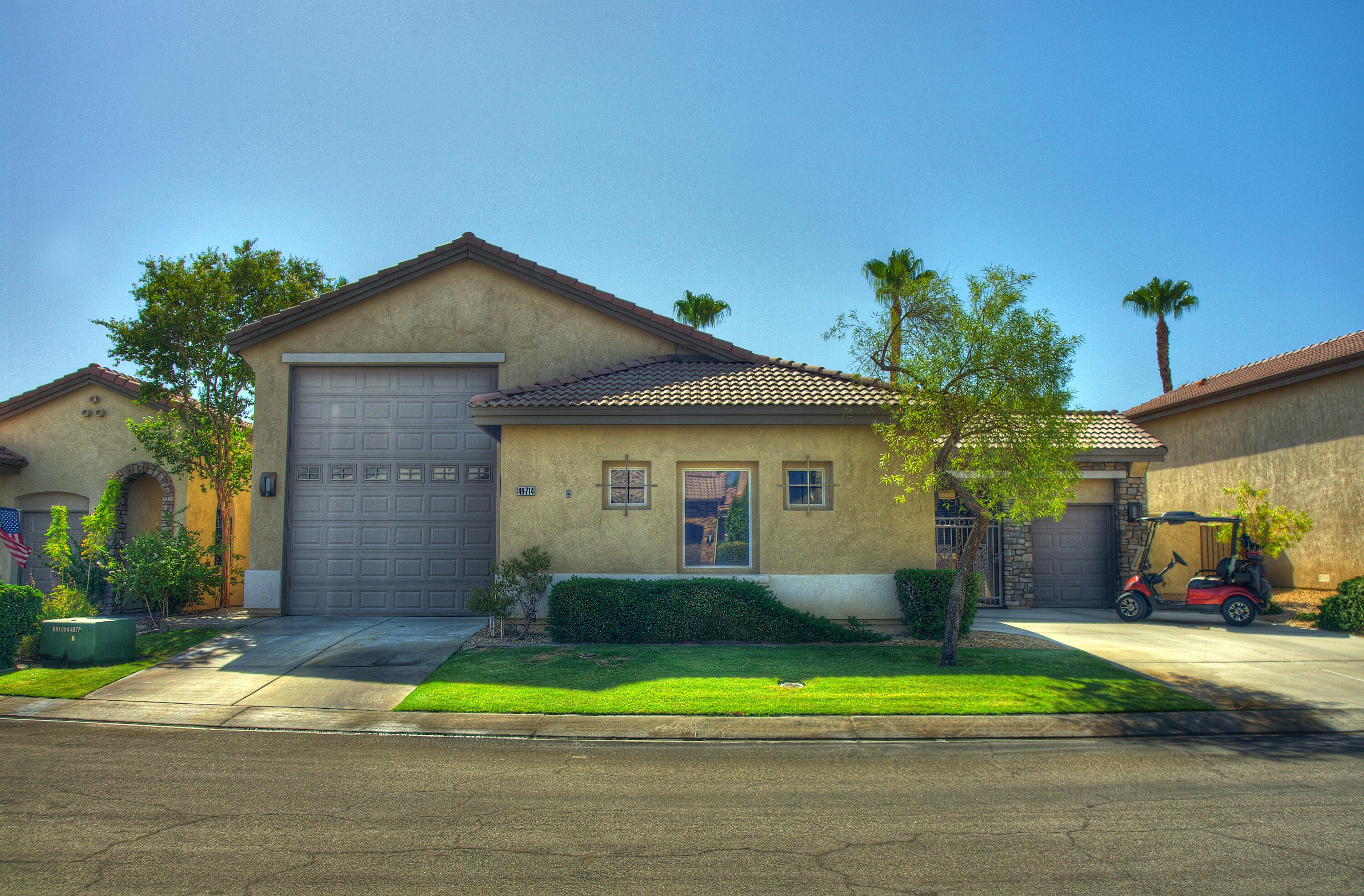 49714 Newman Circle Indio, CA 92201 - Photo 8 of 42 a front view of a house with a yard and garage