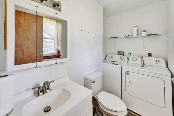 a bathroom with a sink a toilet and a window