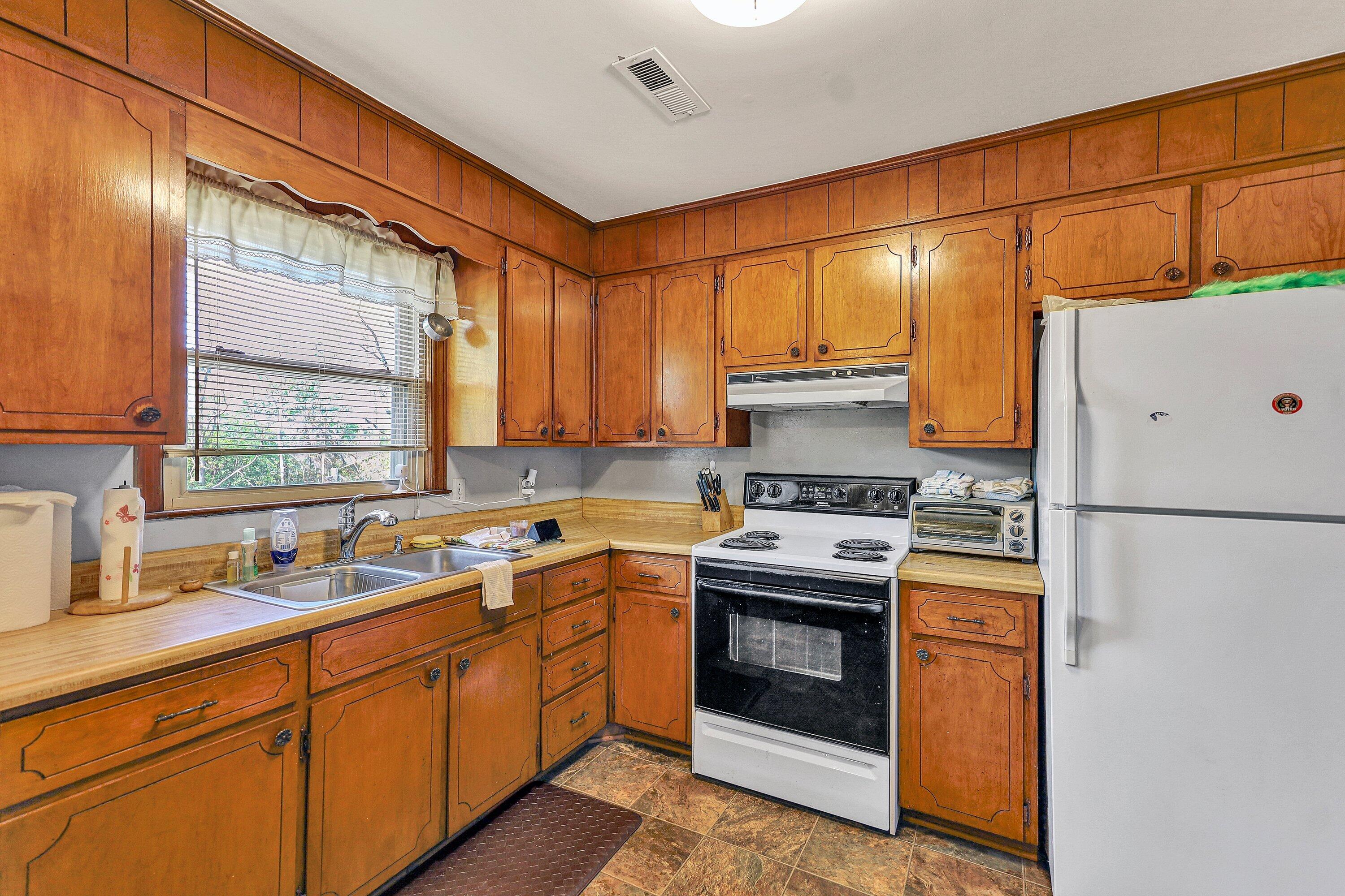 509 Carver Road Martinsville, VA 24112 - Photo 8 of 25 a kitchen with a sink cabinets stainless steel appliances and a window