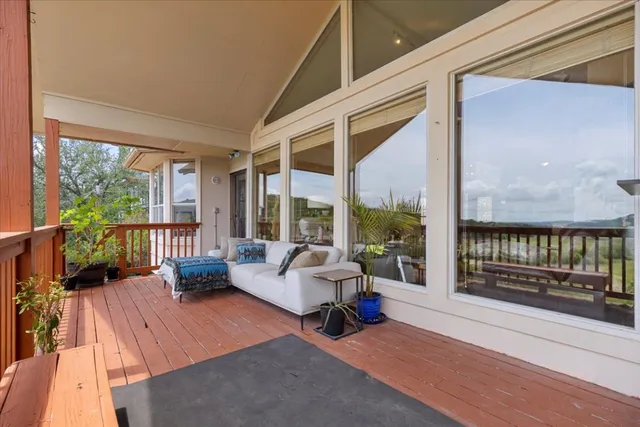 a living room with furniture tv and large windows