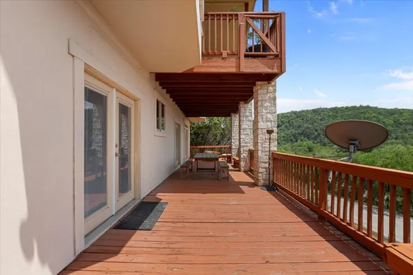 a view of a balcony with wooden floor and iron stairs
