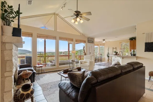 a living room with furniture ceiling fan and a floor to ceiling window