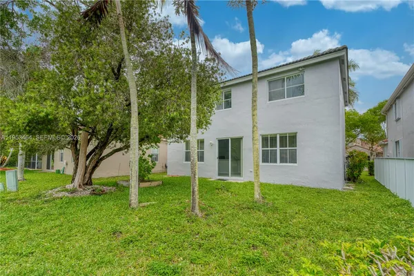 a view of a house with backyard and a tree