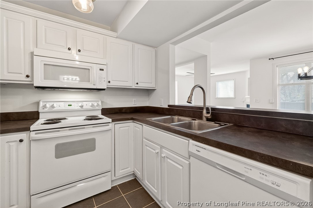 1221 Westview Lane, Unit 301 Raleigh, NC 27605 - Photo 25 of 32 a kitchen with granite countertop white cabinets and white appliances