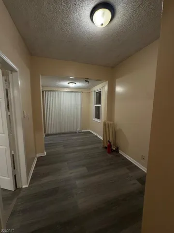 an empty room with wooden floor and entrance