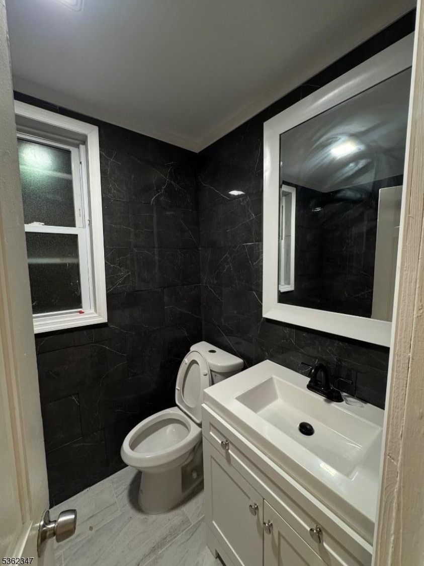 388 East 9th Avenue, Unit 2 Roselle, NJ 07203 - Photo 16 of 24 a bathroom with a sink toilet and mirror