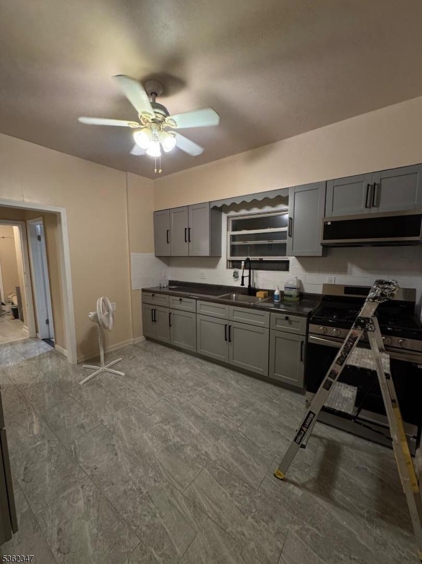 388 East 9th Avenue, Unit 2 Roselle, NJ 07203 - Photo 18 of 24 a kitchen with kitchen island a counter top space appliances and cabinets