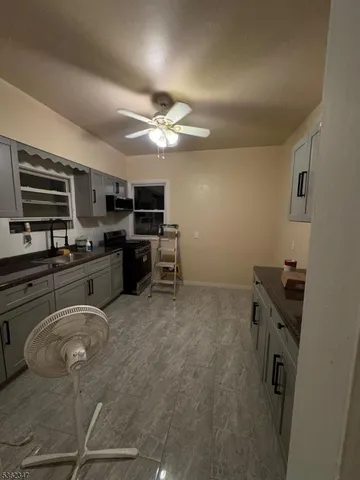 a kitchen with kitchen island granite countertop a stove and a sink
