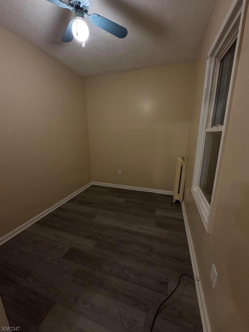 388 East 9th Avenue, Unit 2 Roselle, NJ 07203 - Photo 23 of 24 an empty room with wooden floor and windows