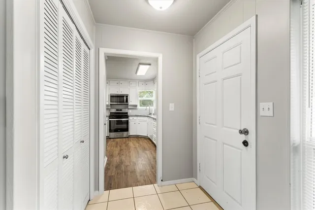 a view of a kitchen from the hallway with windows