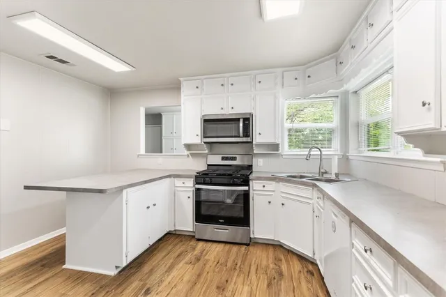a kitchen with a sink cabinets appliances and a window