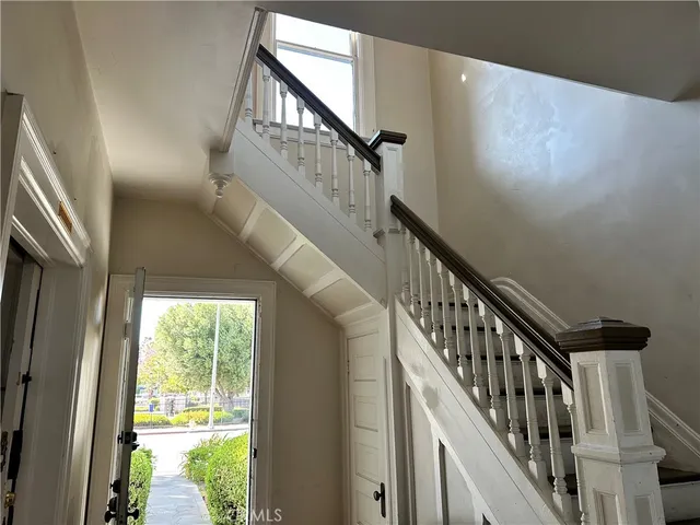 a view of staircase with wooden floor and white walls