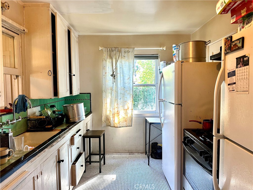 4308 Lime Street Riverside, CA 92501 - Photo 8 of 14 a kitchen with sink a refrigerator and potted plant