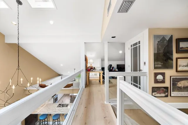 a large white kitchen with wooden floor