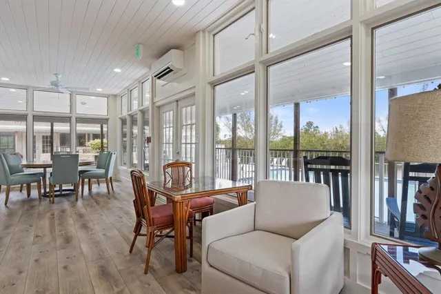 a living room with furniture a floor to ceiling window and wooden floor