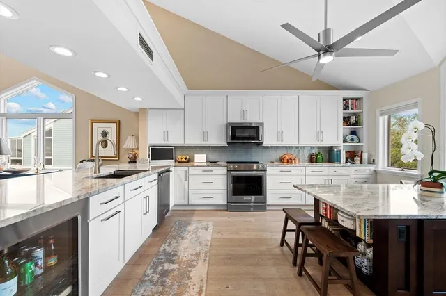 a large white kitchen with cabinets a sink and a stove