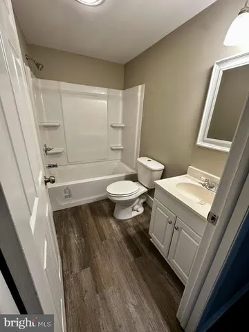 a bathroom with a sink a toilet a tub and shower