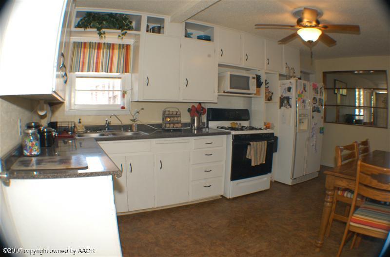4101 South Monroe Street Amarillo, TX 79110 - Photo 5 of 6 a kitchen with stainless steel appliances granite countertop a stove a sink dishwasher and a refrigerator