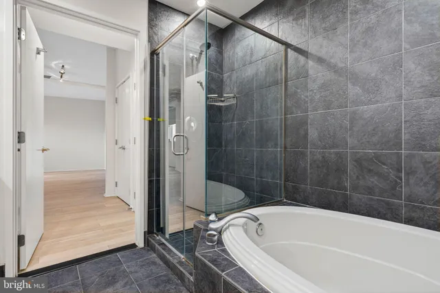 a bathroom with a granite countertop sink a toilet a mirror a vanity and bathtub