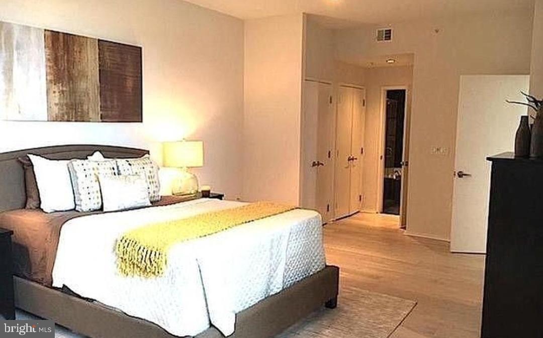 3409 Wilson Boulevard, Unit 301 Arlington, VA 22201 - Photo 36 of 39 a bedroom with a bed and a mirror