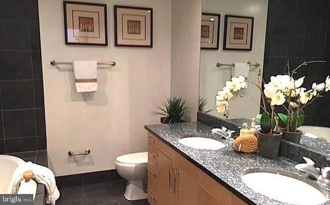 3409 Wilson Boulevard, Unit 301 Arlington, VA 22201 - Photo 38 of 39 a bathroom with a granite countertop toilet sink and mirror