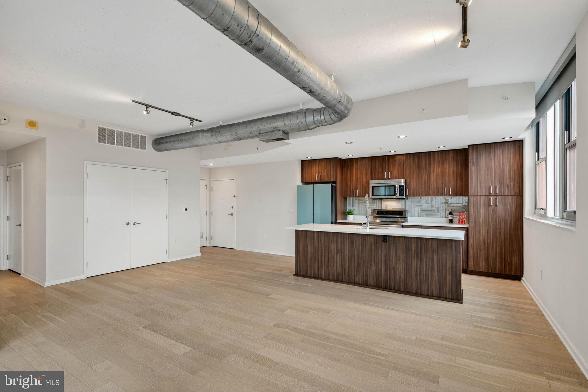 3409 Wilson Boulevard, Unit 301 Arlington, VA 22201 - Photo 7 of 39 a view of kitchen with stainless steel appliances kitchen island sink refrigerator and stove